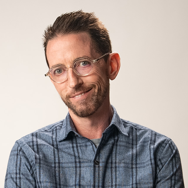 A man wearing glasses and a plaid shirt.